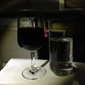 Glasses of wine and water on airplane tray table
