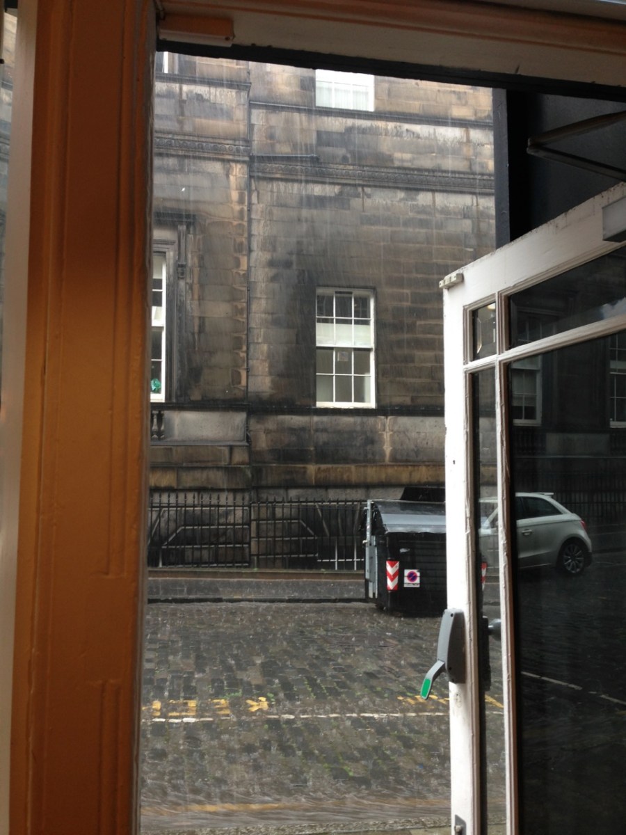 heavy rain falling outside cafe door