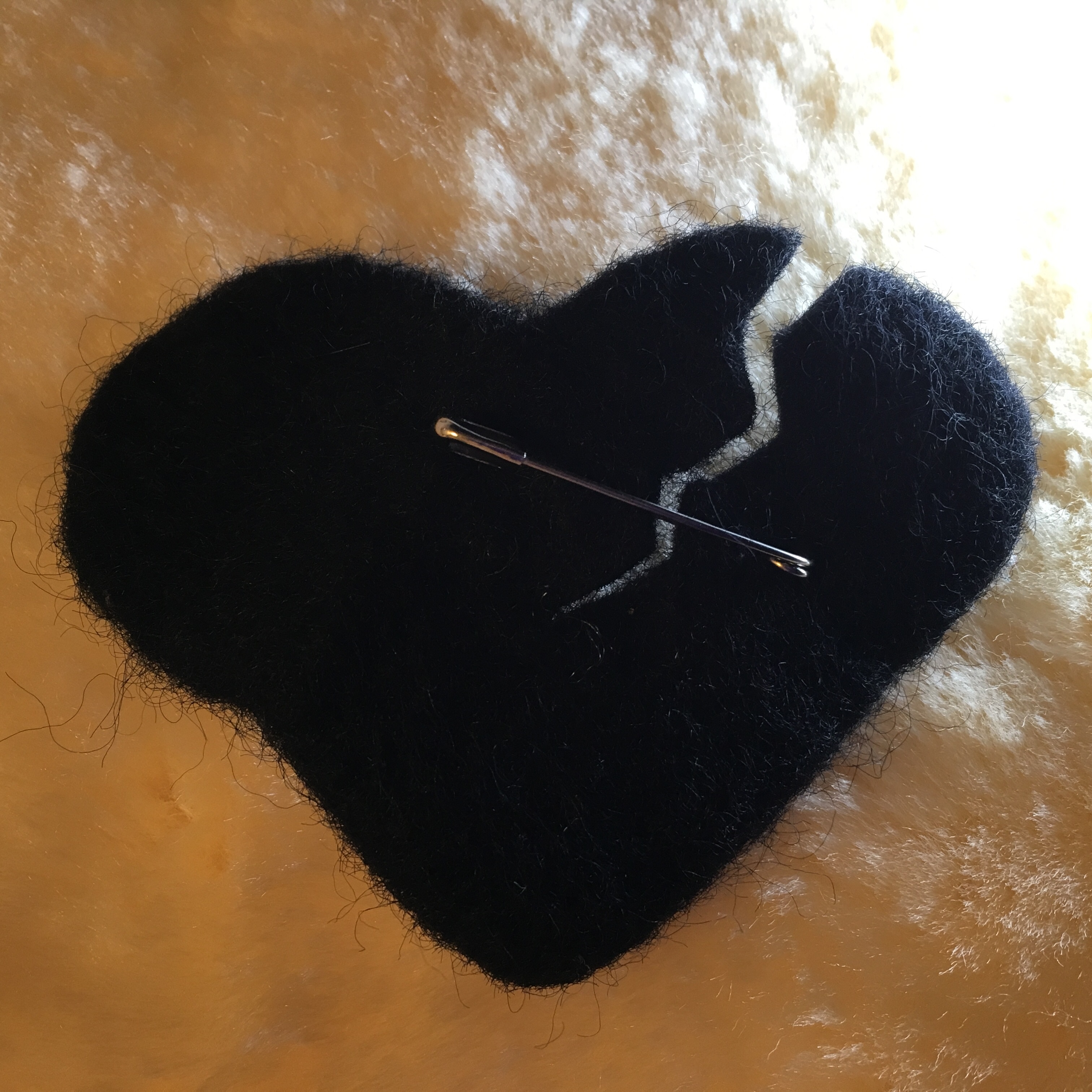 Torn black felt heart pinned to garment to signify grief and k'riah