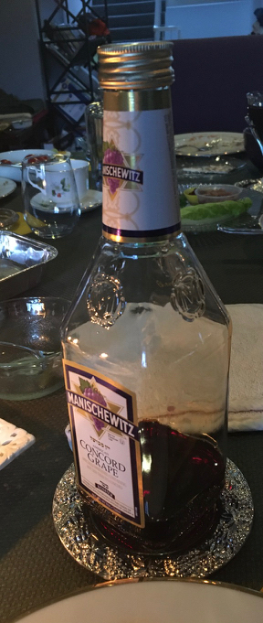 Manischewitz kosher wine bottle, mostly empty, on silver salver