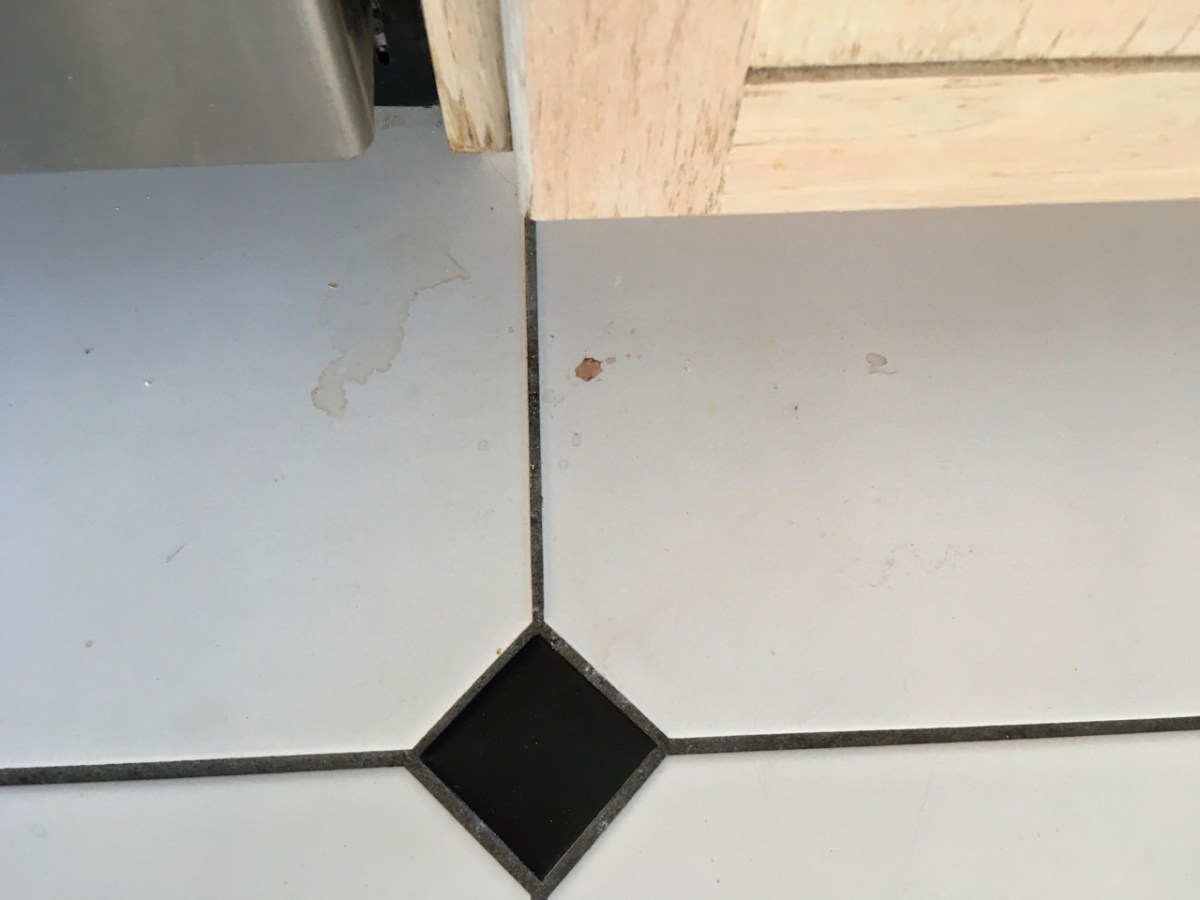 Visible dirt, crumbs and spills on white tile floor
