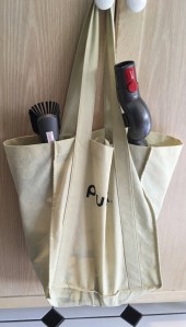 Vacuum accessories in old shopping bag hung from cabinet handle