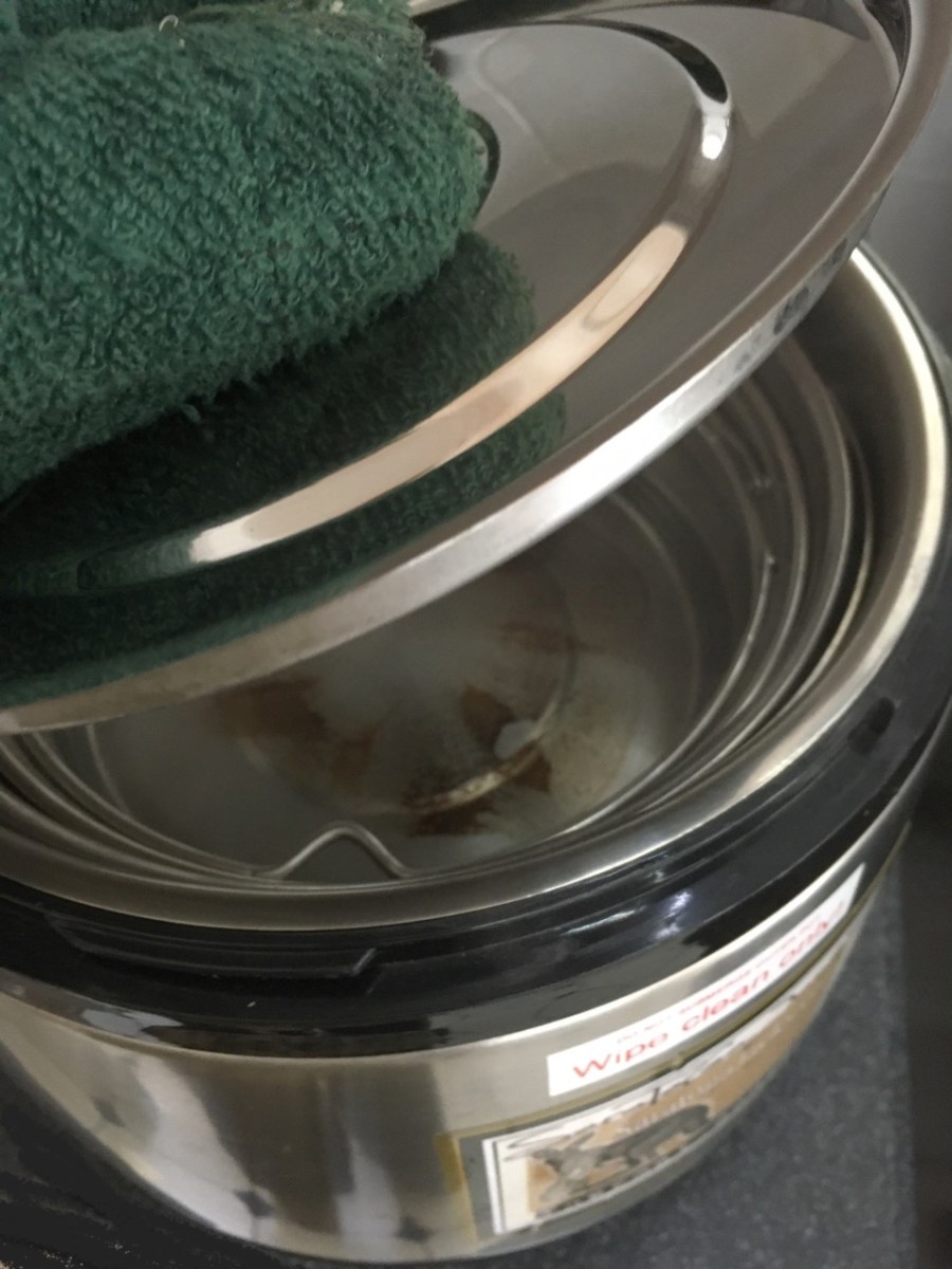 Oven mitt closing lid inside Thermal Cooker with both interior pots filled