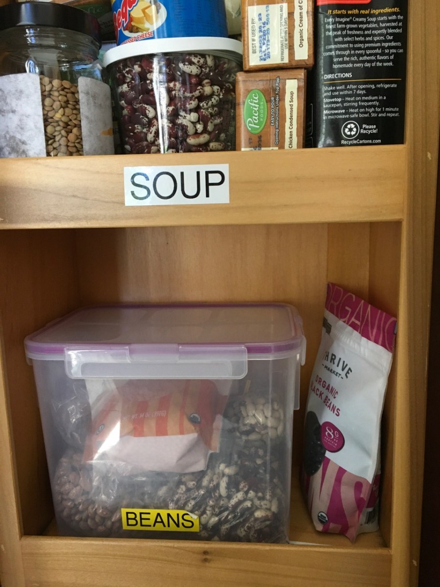 pantry shelf with half a dozen packages of various types of dried beans