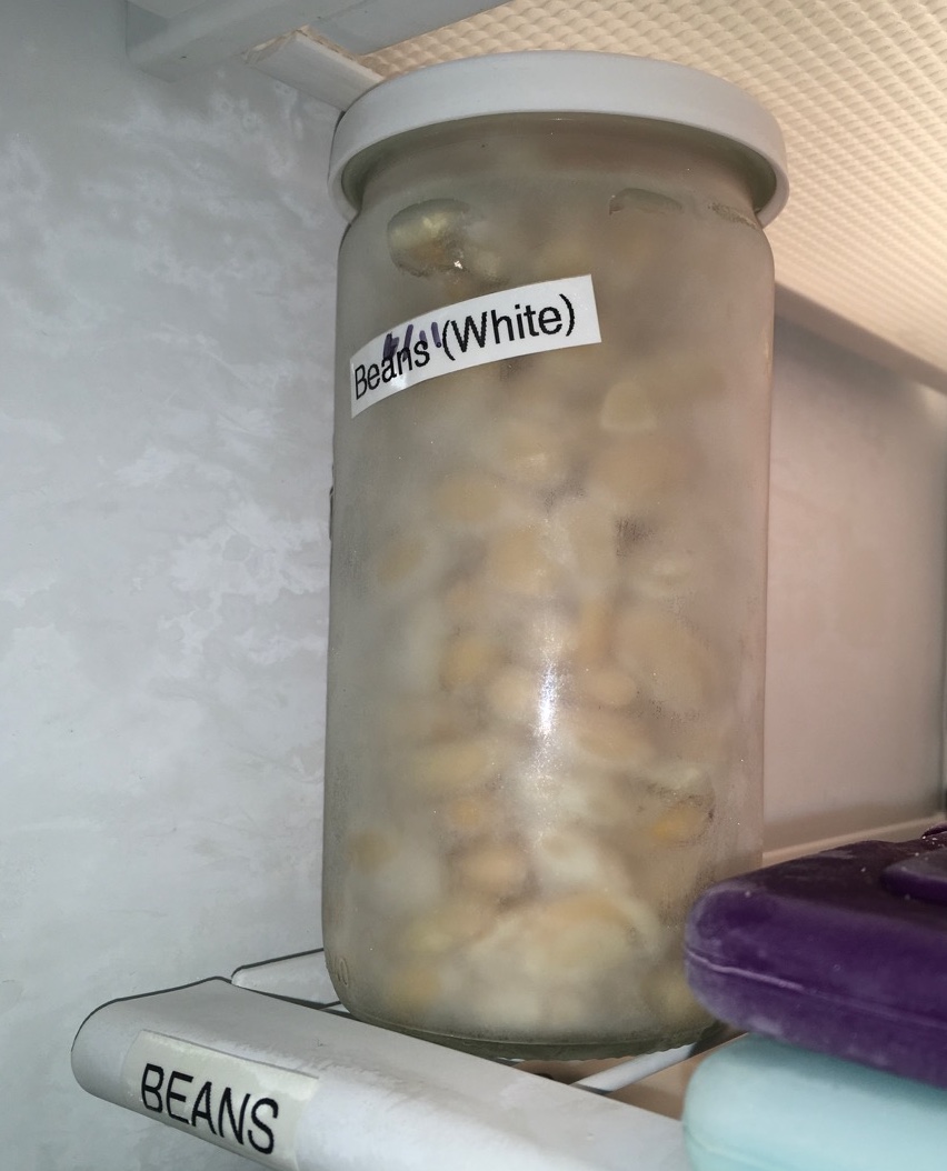 home cooked white beans in jar on freezer shelf