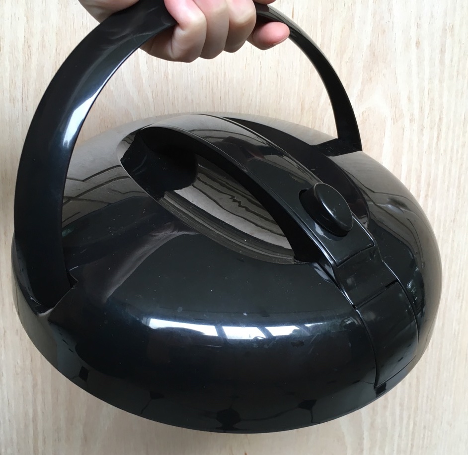 Saratoga Jacks Thermal Cooker lid being held by integrated handle