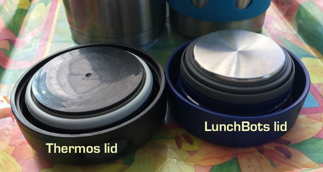 Black plastic Thermos lid next to blue plastic LunchBots lid whose interior is lined with stainless steel