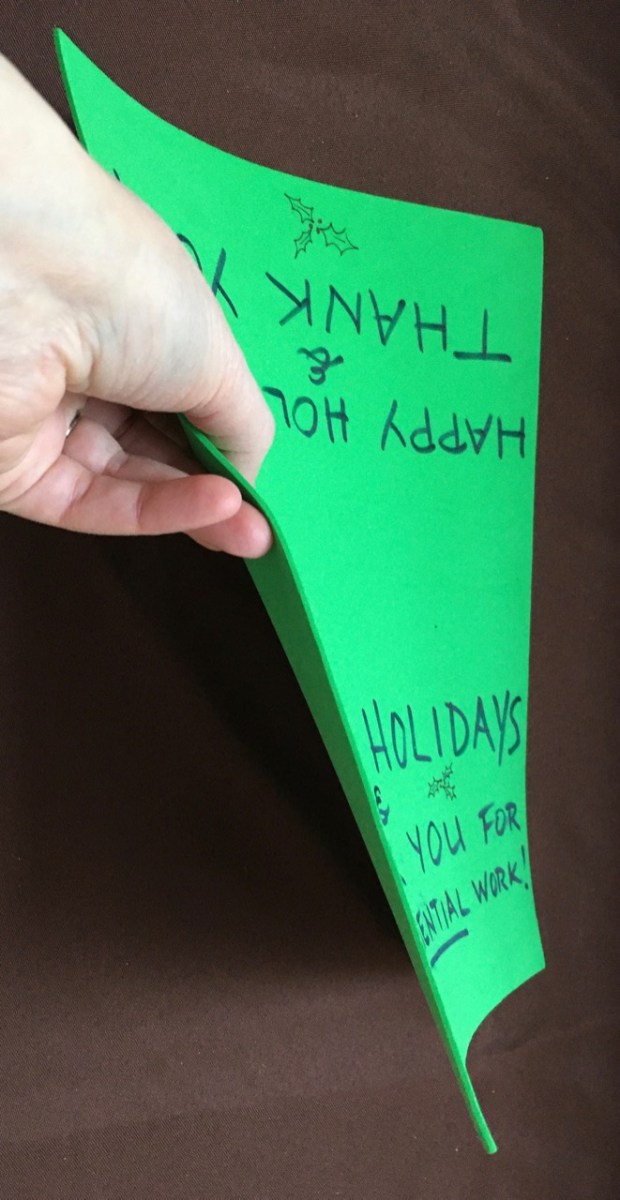 hand demonstrating flexibile nature of green foam "paper"