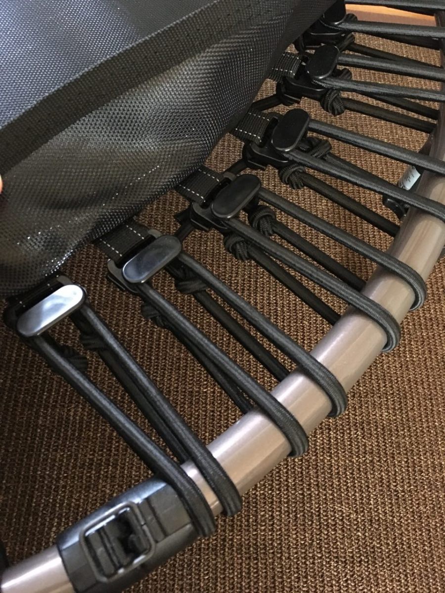 Close up of bungee cords with jumping surface skirt lifted to show how they attache to frame