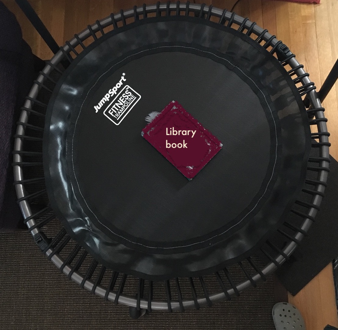 Hardback library book on JumpSport fitness trampoline to show relative size