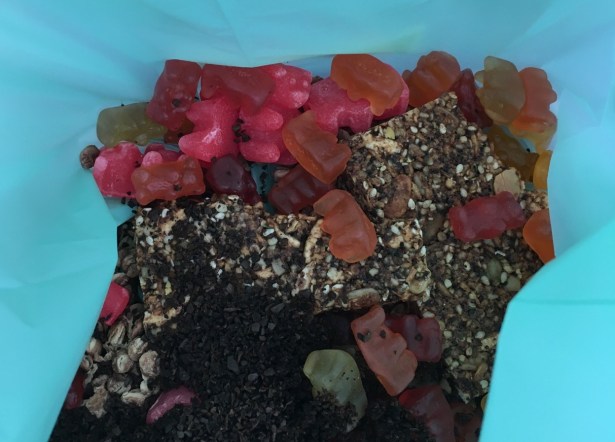 food in kitchen compost pail including gummy bears, coffee grounds, oatmeal, and seeds