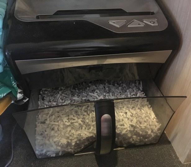 small countertop paper shredder with basket open for retrieval of paper shreds