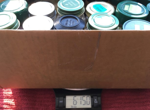 Box of spices on kitchen scale showing weight of 6 pounds, 15 ounces