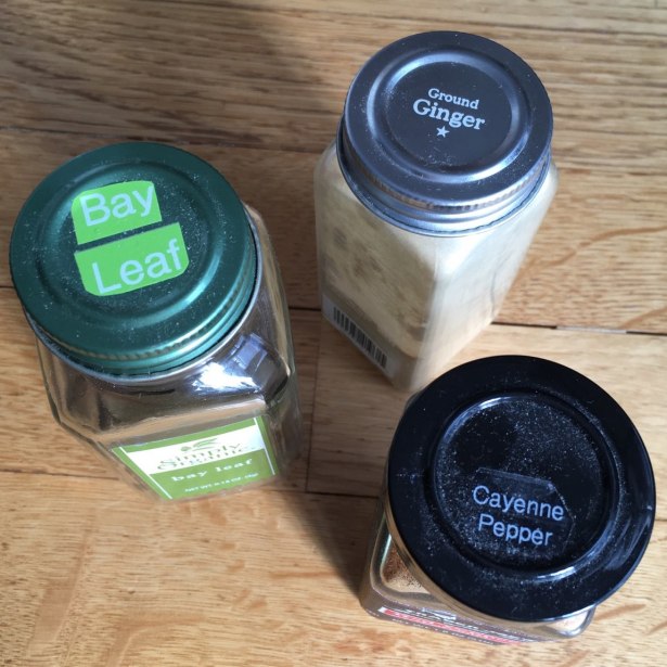Spice jar tops with raised ring on green Simply Organic lid, silver Whole Pantry lid, and black plastic Trader Joe's lid
