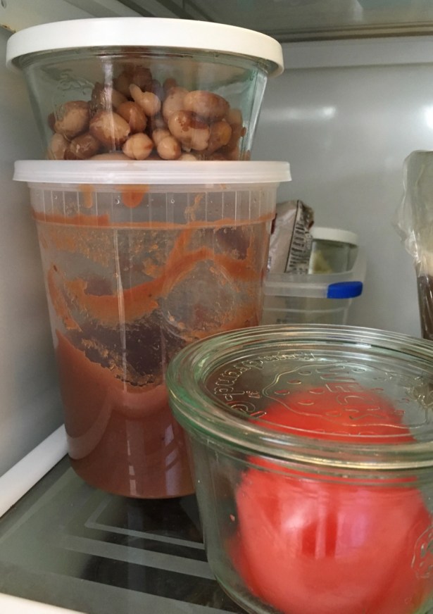 View into fridge with leftover beans in Weck 740 jar stacked on similar diameter deli quart of applesauce
