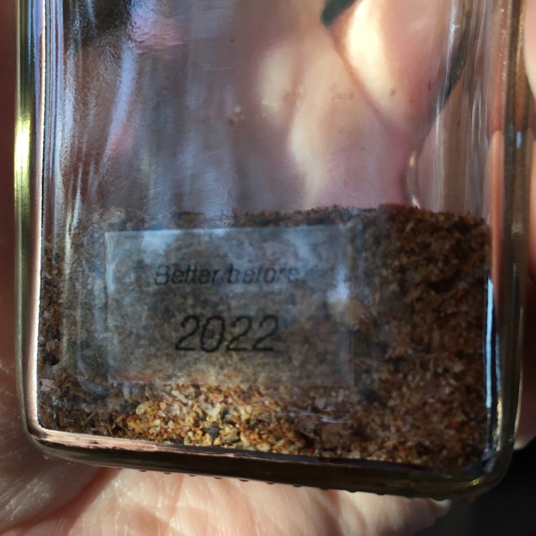 Clear label with black text reading Better before 2022 applied to glass seasoning bottle