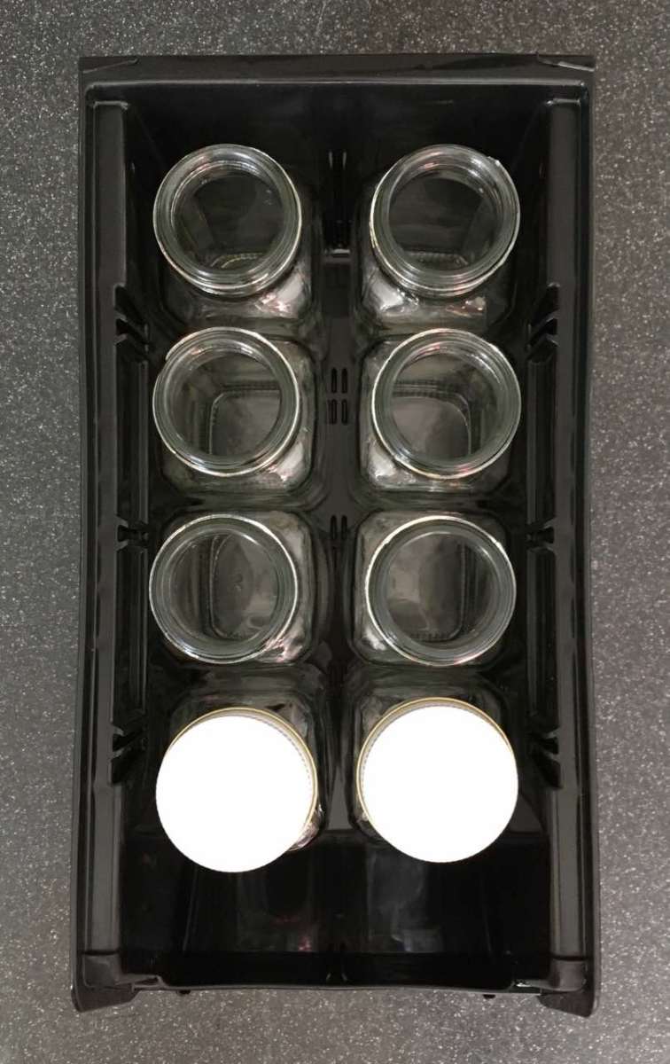 View from above showing 8 6 fl oz jars in a bin