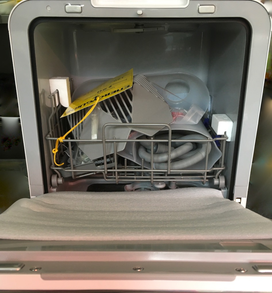 View of interior packed for shipping with all dishwasher accessories
