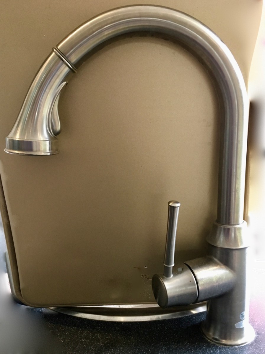 Kitchen sink with tall nickel finished faucet