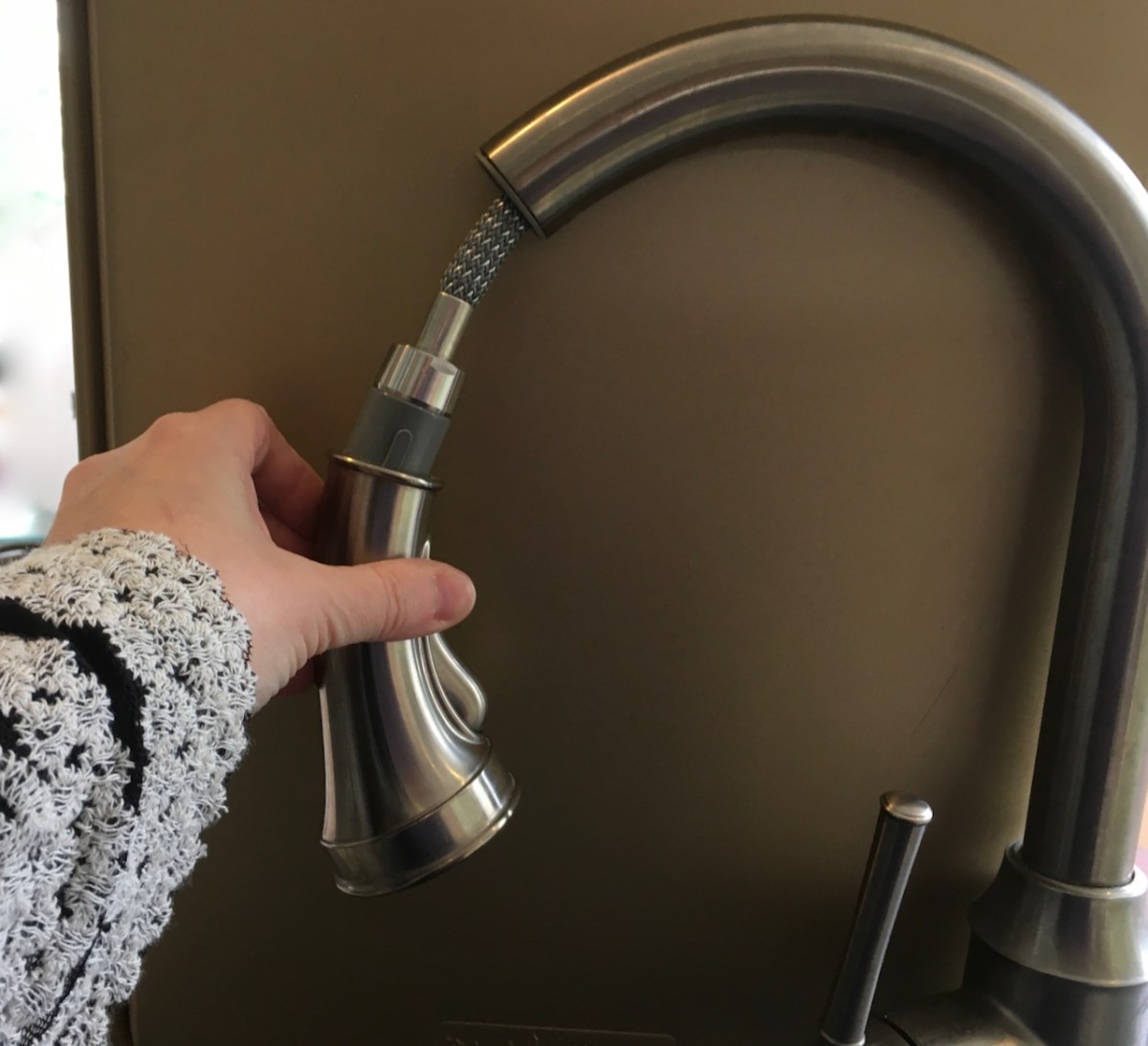 Pull out spray head partially extended from kitchen faucet