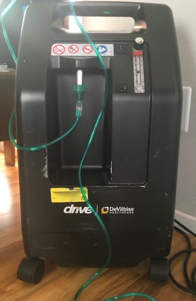 Oxygen machine with long green tube attached