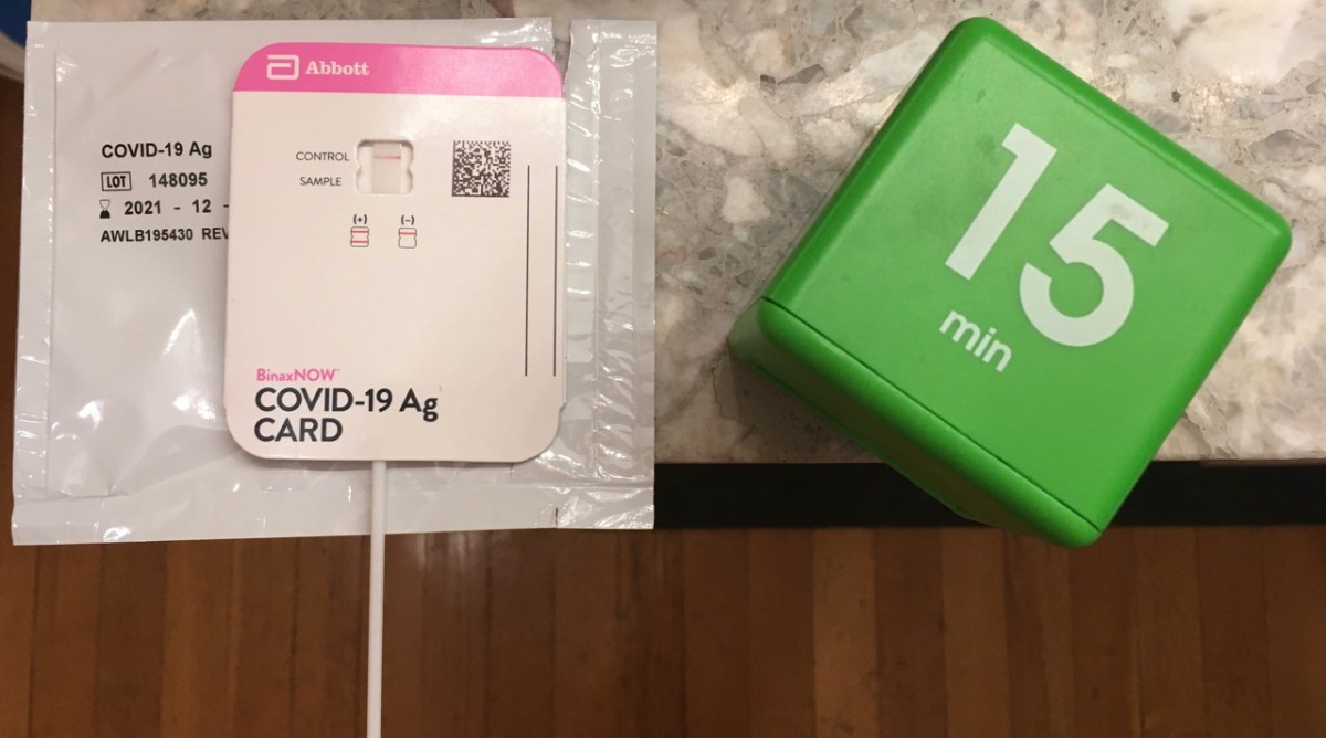Home COVID-19 test components on counter with 15 minute timer