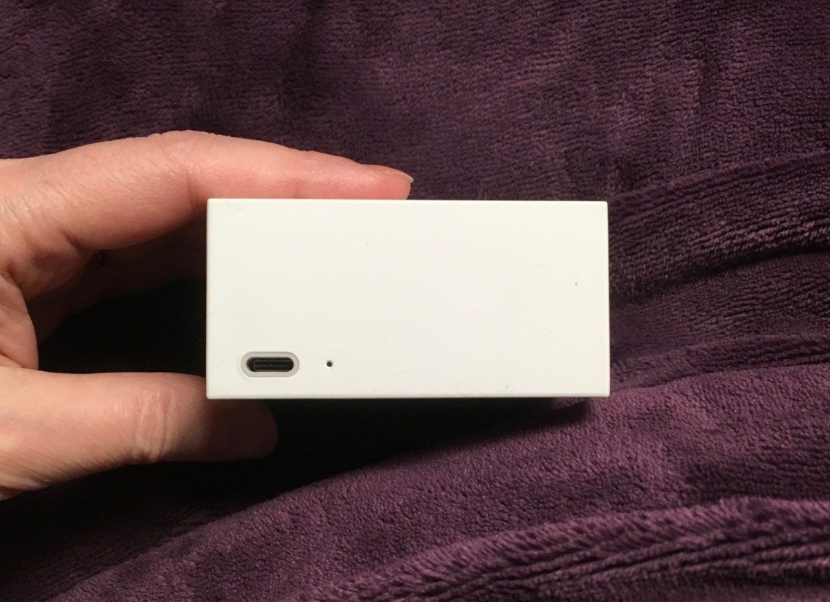 Rear side of Cue Reader with power port at the bottom left and tiny reset button next to it