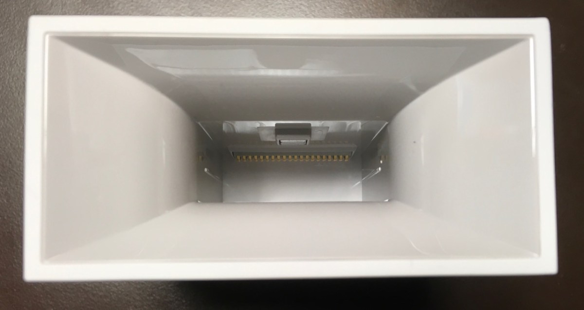 contacts and a small opening visible deep inside mostly smooth plastic interior of device