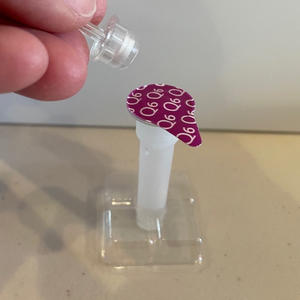 COVID test tube in stand awaiting insertion of swab and drop-dispensing cap