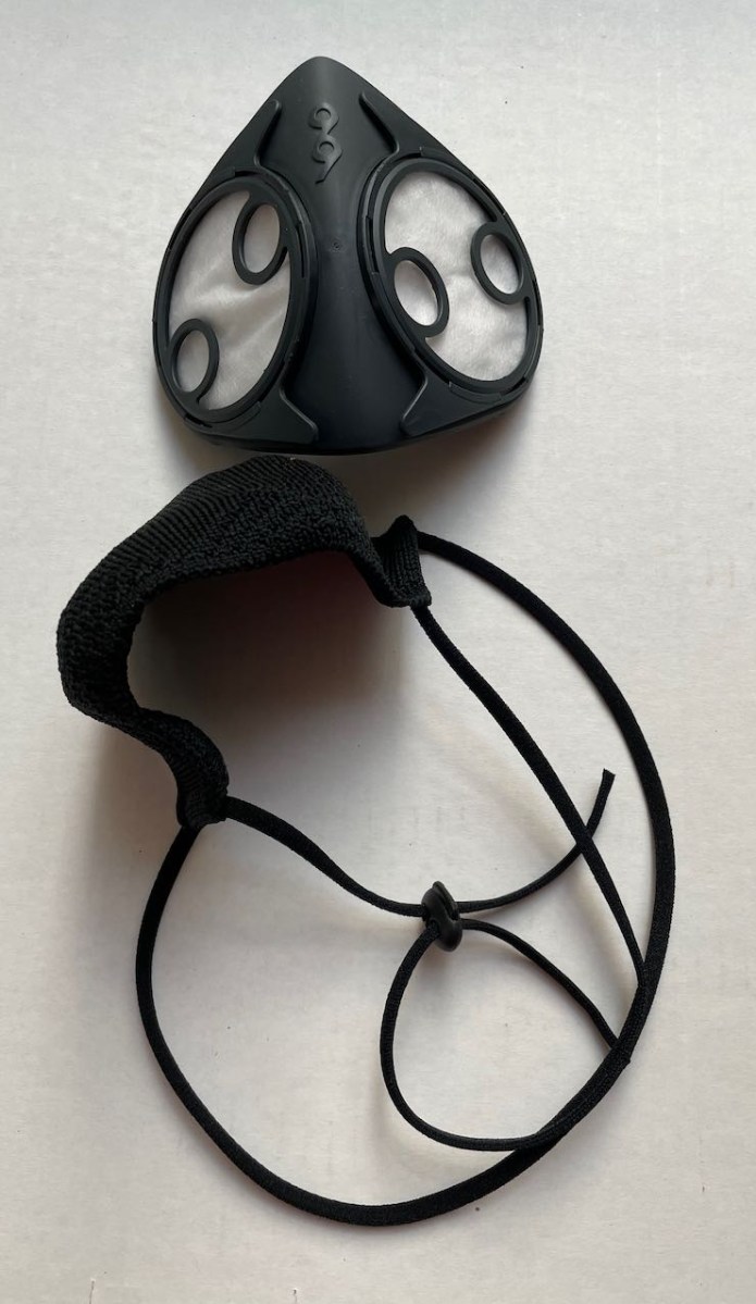 B2 Mask face piece, filters and caps installed, next to fabric overlay with straps