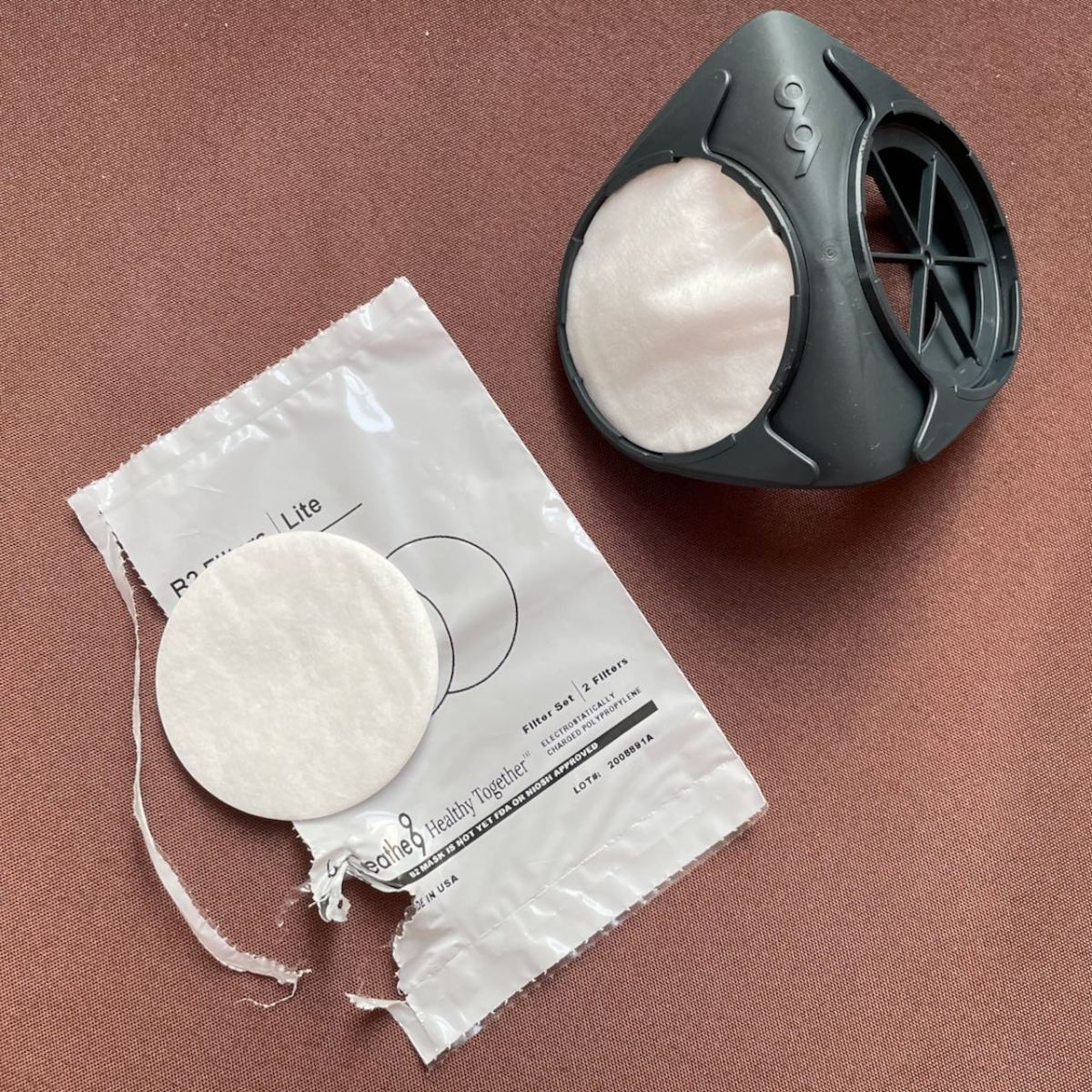 Ergonomic face piece with one filter inserted but no cap installed