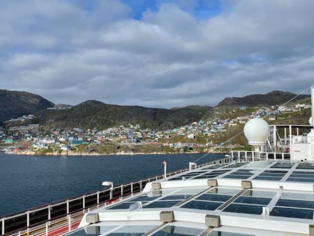 Clouds and sun over harborside buildings visible from Nieuw Statendam