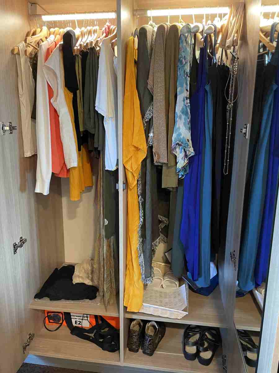 Closet with ladies' clothing hung up neatly by type of garment