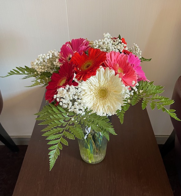 Holland America line florist bouquet by request in tall vase with red, pink and white blooms