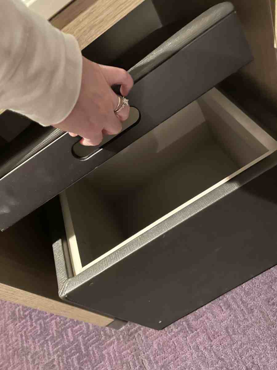 Ladies hand holds lid open on storage ottoman/bench