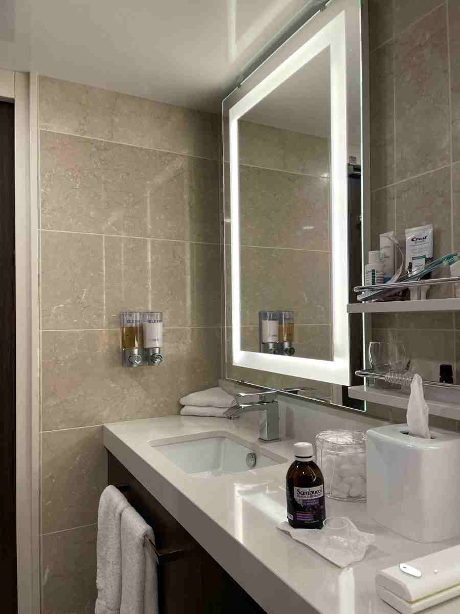 View of one of 2 sink with about 2 ft of space between them and shelves above