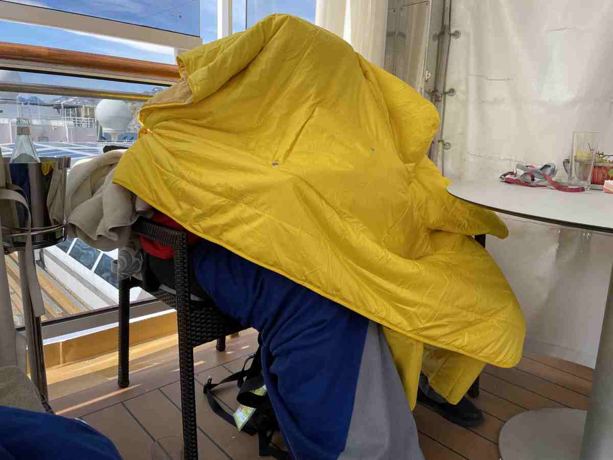 Two teens huddled under one poncho