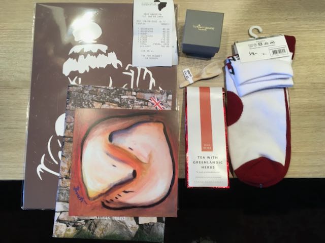 Artwork, book, card, tea, socks, earrings in a box, and hand carved driftwood salt scoop on desk with receipt