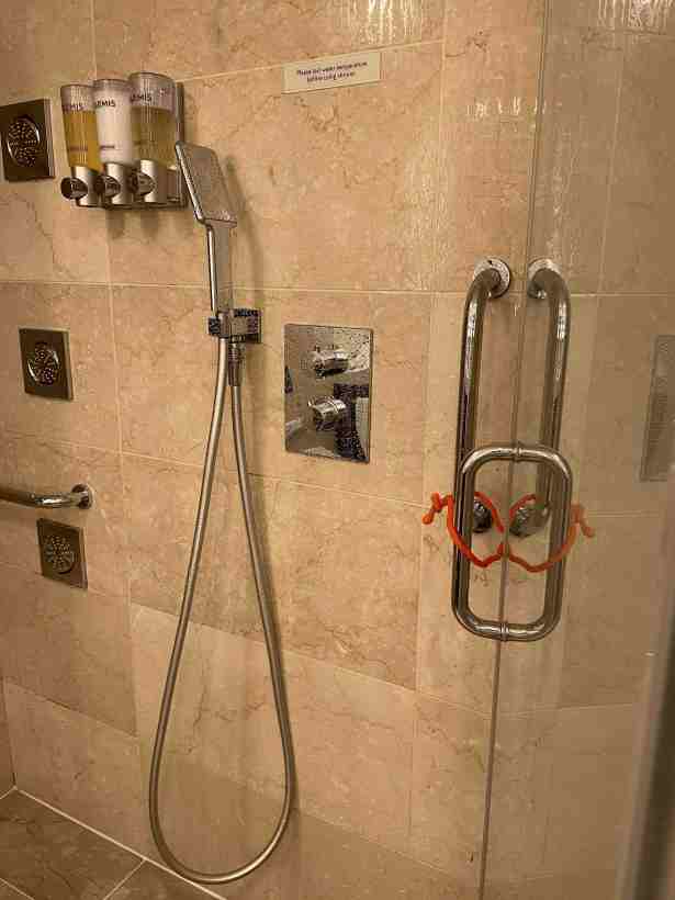 Orange rubber coated flexible wire binding shower door handle to